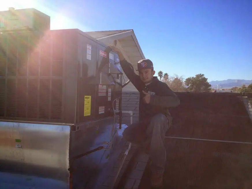 HVAC technician performing Air Duct Repair on a rooftop unit in Fairview